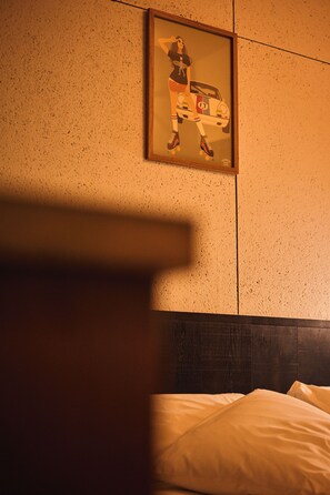 Una habitación de hotel con una cama, un cuadro enmarcado en la pared y un revestimiento texturizado.