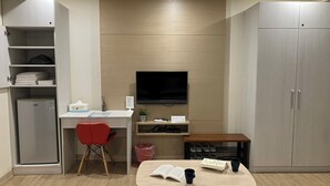 A compact room with a desk, chair, television, and wardrobe. - Formosa Boulevard Music City (Kaohsiung)