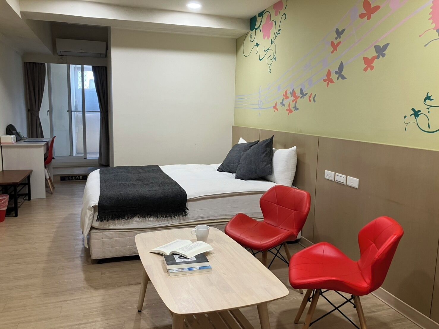 Una habitación de hotel con una cama, un escritorio, una silla y una mesa.