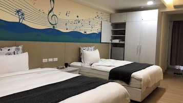 A hotel room with two beds, a wardrobe, a desk, and a wall mural.