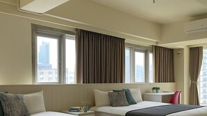 A hotel room with two beds, a desk, and a chair. There are large windows with curtains, and an air conditioning unit on the wall. - Formosa Boulevard Music City (Kaohsiung)