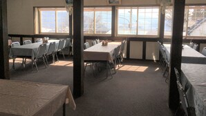 A room with tables and chairs, large windows, and ceiling fans. - Kitashiga Lime Light (Yamanouchi)