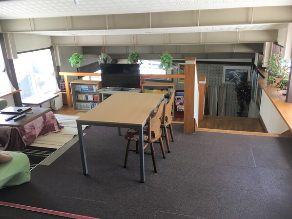 A room with a dining table, chairs, a television, bookshelves, and potted plants. - Kitashiga Lime Light (Yamanouchi)