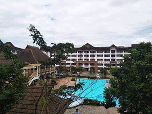 A hotel with a swimming pool, a covered area, and a large building with multiple balconies. - 1BR Unit For Rent One Oasis Condominium (Davao)