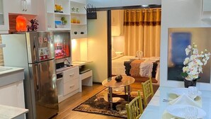 Una cocina moderna con un refrigerador, una mesa de comedor para dos personas y un ventilador de techo.