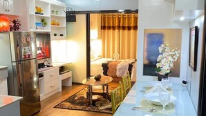 Una cocina moderna con refrigerador, una mesa de comedor para dos personas y un ventilador de techo.