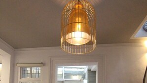 A spacious hallway with a tiled floor, a large door with a glass panel, and a hanging light fixture. - Tainan Travel Inn (Tainan)