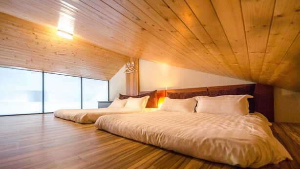 A spacious bedroom with a wooden ceiling and large windows. - Tainan Travel Inn (Tainan)