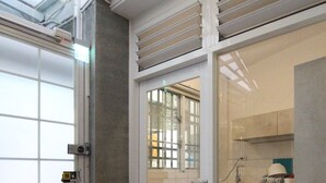 A modern kitchen with a sliding glass door leading to a bathroom. - Tainan Travel Inn (Tainan)
