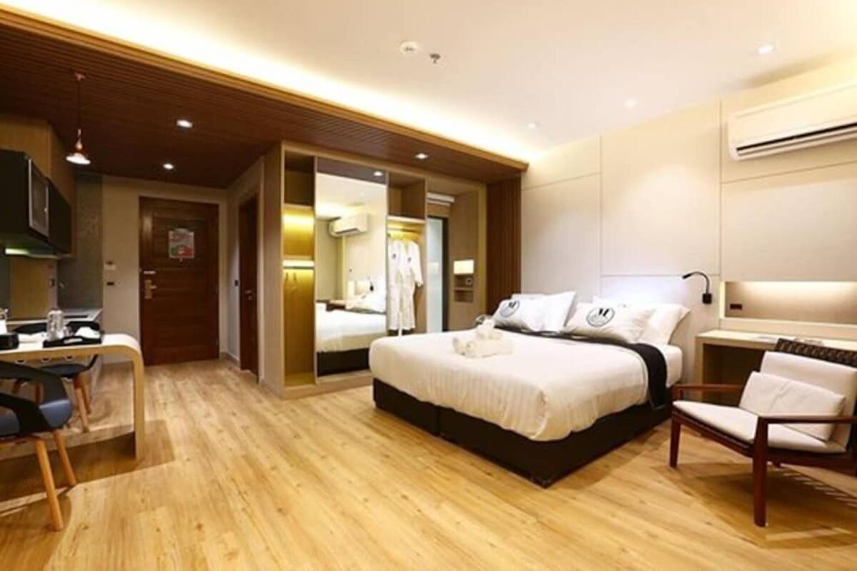 Una habitación de hotel con cama, escritorio, silla y armario.