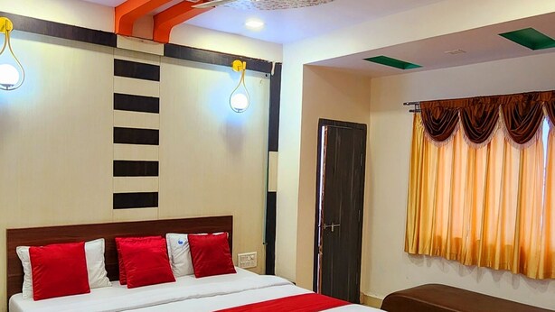 A modern bedroom with a large bed, a ceiling fan, and a decorative ceiling. - Hotel Satpura Safari (Pipariya)