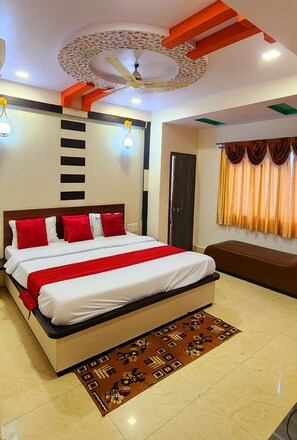 A modern bedroom with a large bed, a ceiling fan, and a decorative ceiling. - Hotel Satpura Safari (Pipariya)
