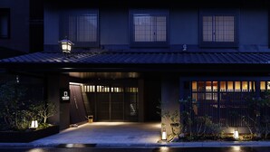 A traditional Japanese-style building with a dark facade, large sliding doors, and a tiled roof.