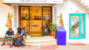 Une devanture de magasin avec une enseigne colorée sur laquelle on peut lire « GOSTOPS » et une adresse de site web.