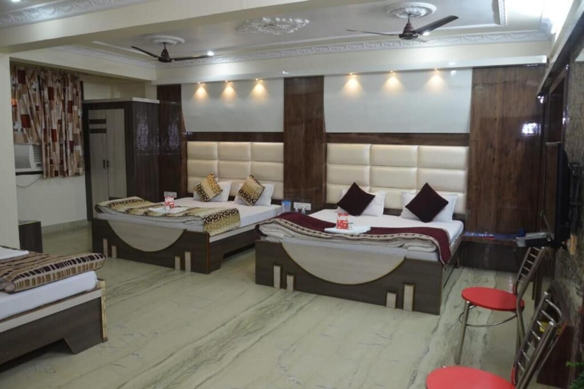 A hotel room with two beds, a ceiling fan, and a red chair.