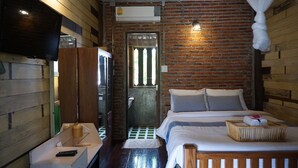 Una habitación con cama, televisión, armario y espejo.
