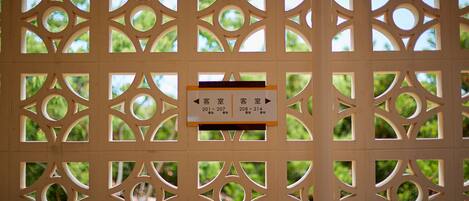 A decorative wooden partition with a sign indicating room numbers 201-207 and 208-214 for the guest room.