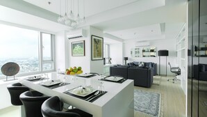 Una cocina moderna con una isla central, sillas de comedor y un amplio ventanal con vista a la ciudad.