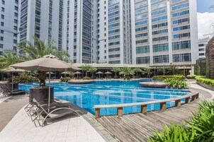 Una piscina al aire libre, sillones reclinables de piscina
