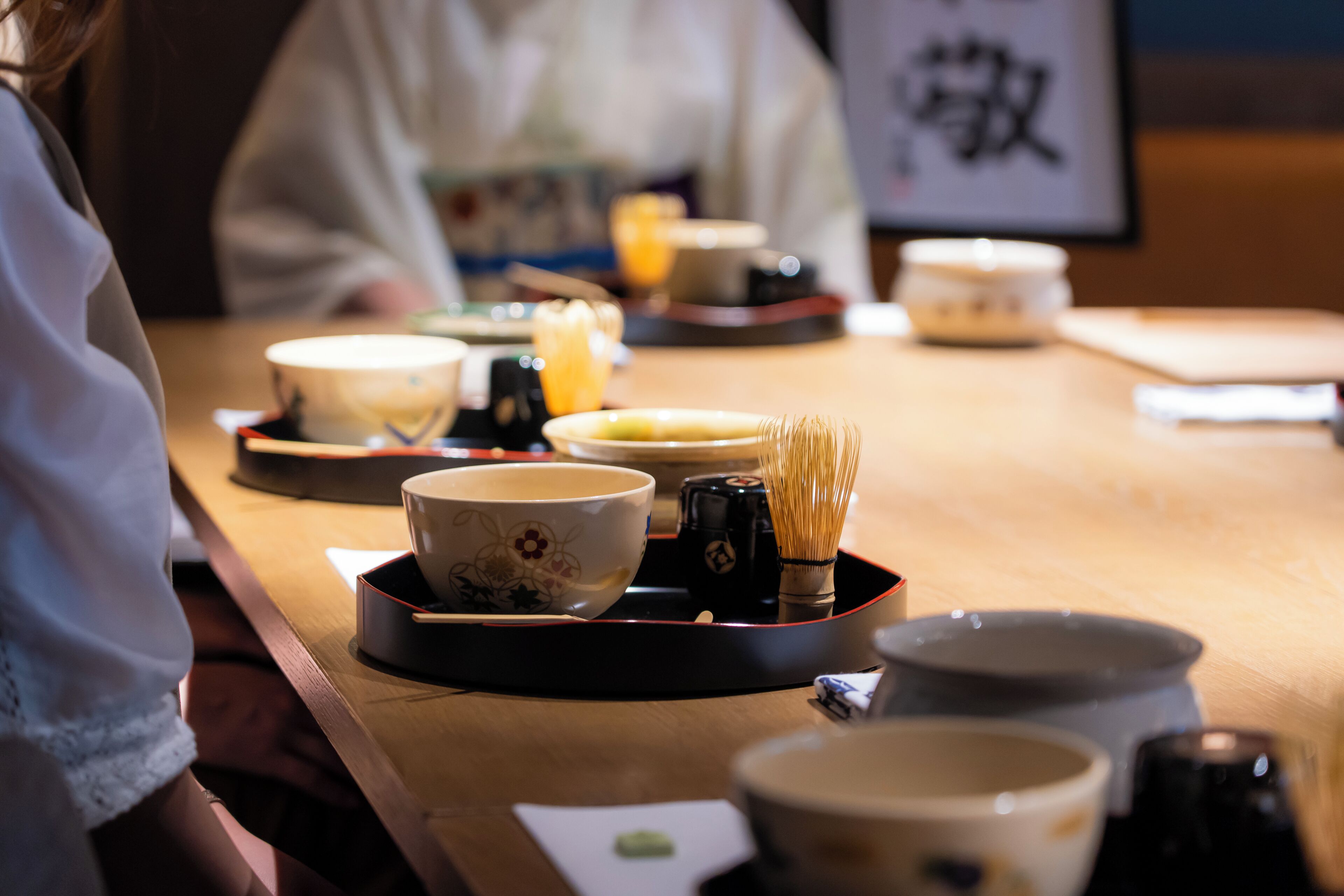 A table with various bowls and a whisk, suggesting a dining setting.