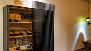 A display case with various items, including bags and boxes, against a textured wall.