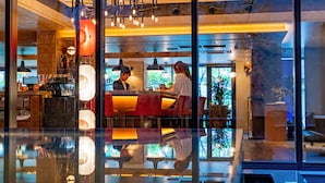 A modern interior with a bar area, reflective floor, and large windows.