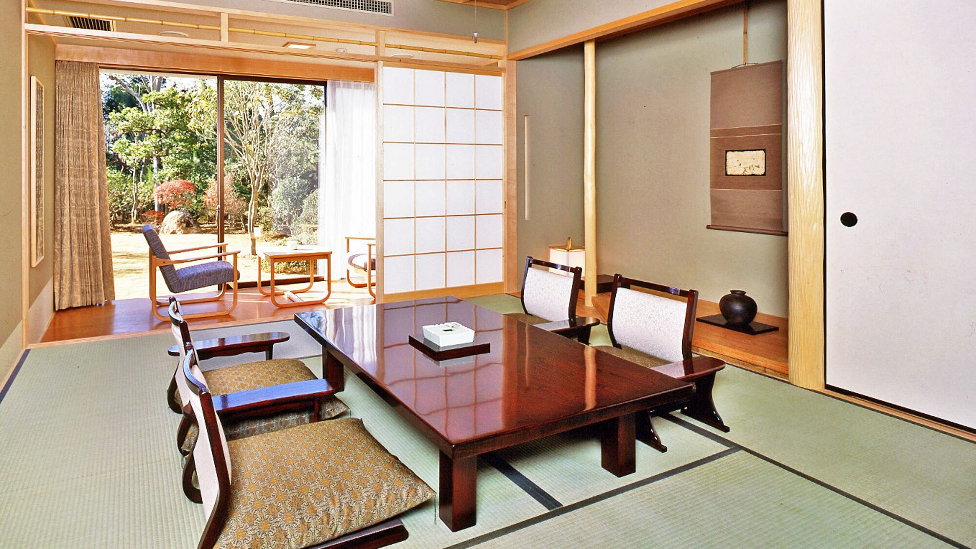 A traditional Japanese room with tatami flooring, a low wooden table, and shoji screens.