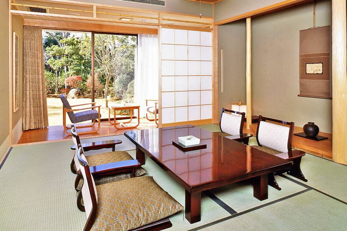 Ein traditioneller japanischer Raum mit Tatami-Böden, einem niedrigen Holztisch und Shoji-Schirmwänden.