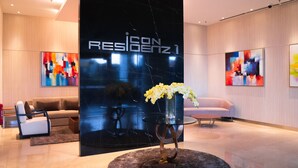 A modern lobby with a black marble reception desk, a sofa, and abstract art on the walls. - Iconic Homestay (Kota Kinabalu)