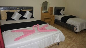 A hotel room with two beds, a wooden desk, and a mirror. - New Bintang Bajawa (Bajawa)