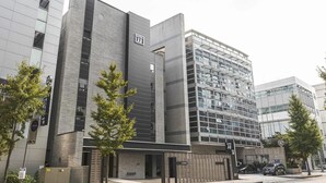 A modern hotel with a prominent 'HOTEL' sign, large windows, and a parking area. - JJ Hotel (Seongnam)