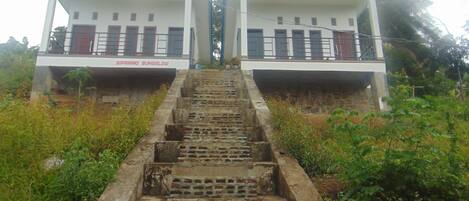 A set of outdoor stairs leading to a bungalow with a sign reading "GIPRIANO BUNGALOW".
