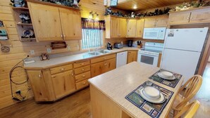 Eine Holz-Küche mit Schränken, einer Mikrowelle, einem Backofen und einem Spülbecken.