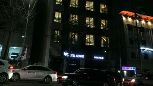A multi-story hotel with illuminated signage, including "HOTEL SENNE" and "PARKING" signs. - Hotel Senne (Seoul)