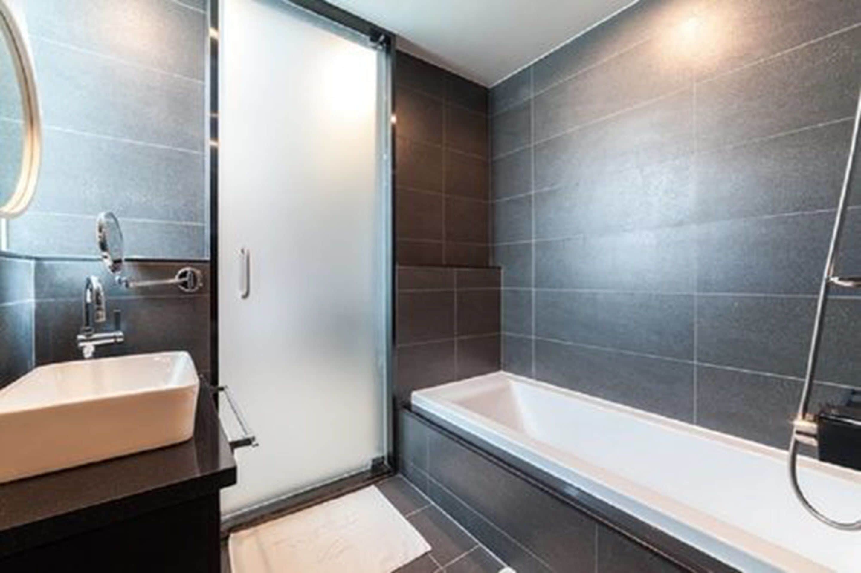 junior suite | bathroom | combined shower/bathtub, deep-soaking bathtub, free toiletries