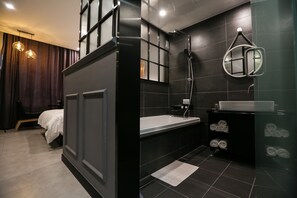 A modern bathroom with a bathtub, a sink, and a mirror. - Hotel Senne (Seoul)