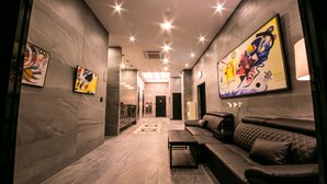 A modern lobby with a marble floor, a sofa, a coffee table, and abstract art on the walls. - Hotel Senne (Seoul)