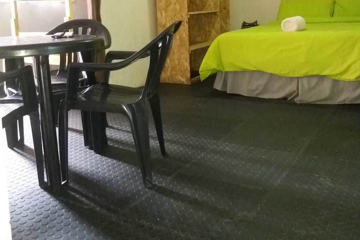 Um quarto com cama, uma mesa e cadeiras, e um guarda-roupa.