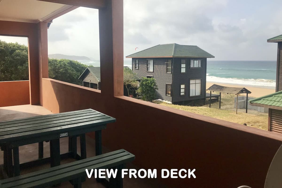 Um terraço com vista para a praia e o oceano.