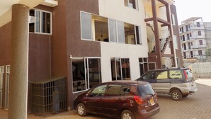 A multi-story residential building with a modern design, featuring balconies and large windows. - Remmings Hotel (Kampala)