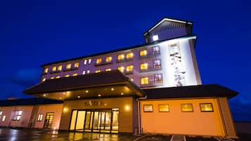 Vista frontal de la propiedad por la tarde o noche