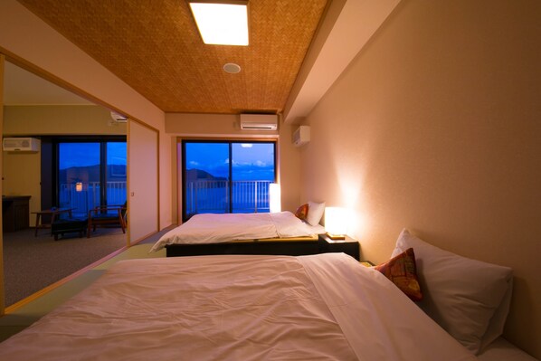 Habitación de hotel con dos camas, un ventanal con vistas y un techo de madera decorado.