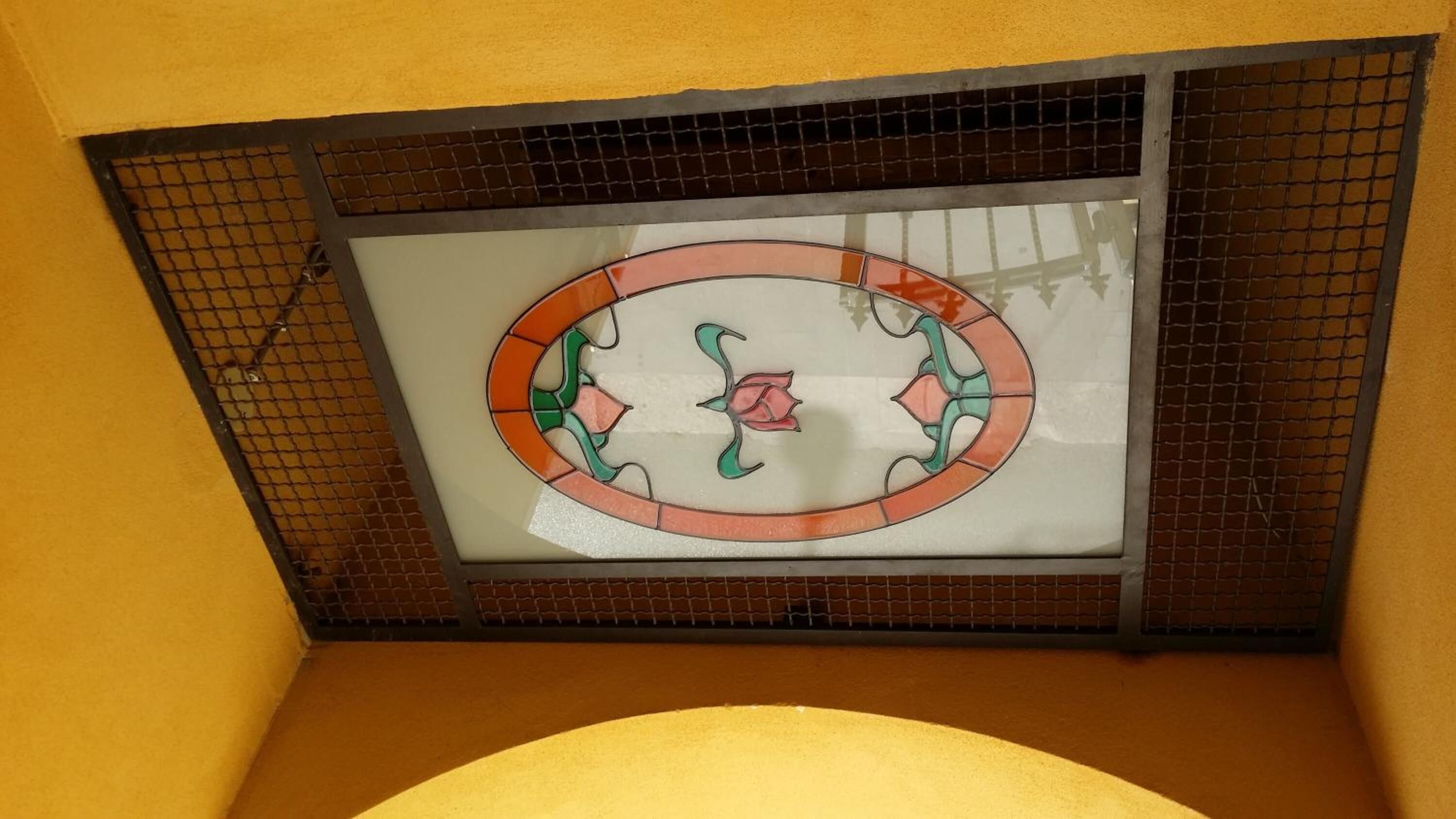 Une fenêtre en vitrail ornée de motifs floraux.