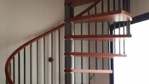 A spiral staircase with wooden steps and metal railings, leading to an upper floor. - Terra del Sole B&B (Vittoria)