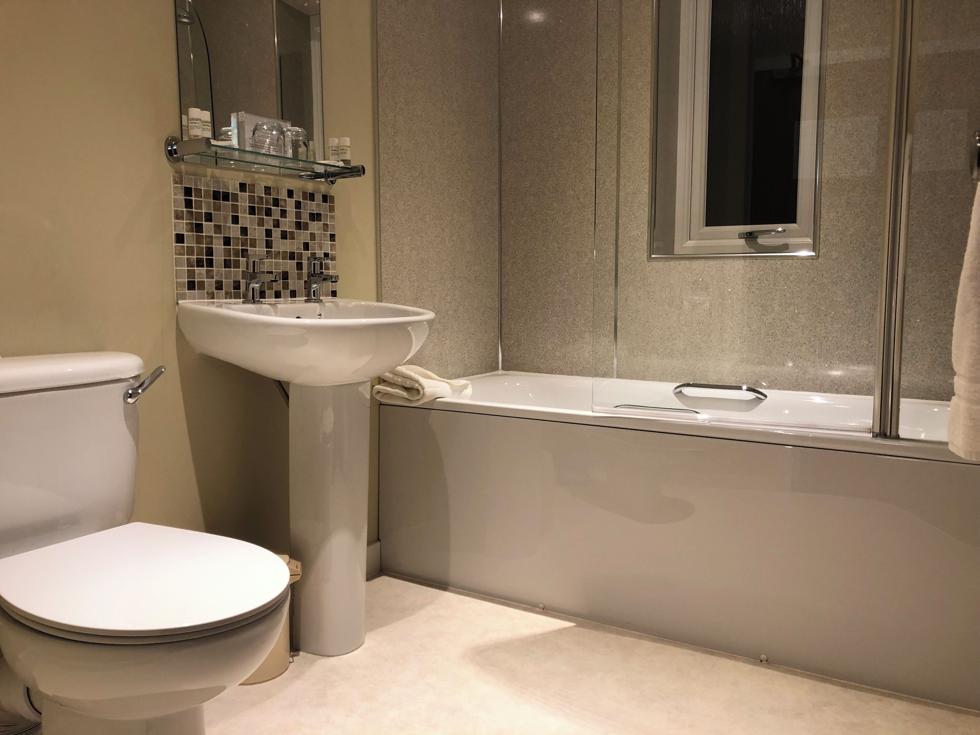 Ein modernes Badezimmer mit Toilette, Waschbecken und Badewanne.