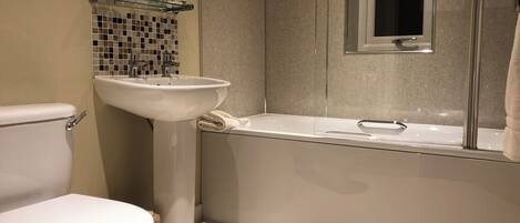 Ein modernes Badezimmer mit Toilette, Waschbecken und Badewanne.