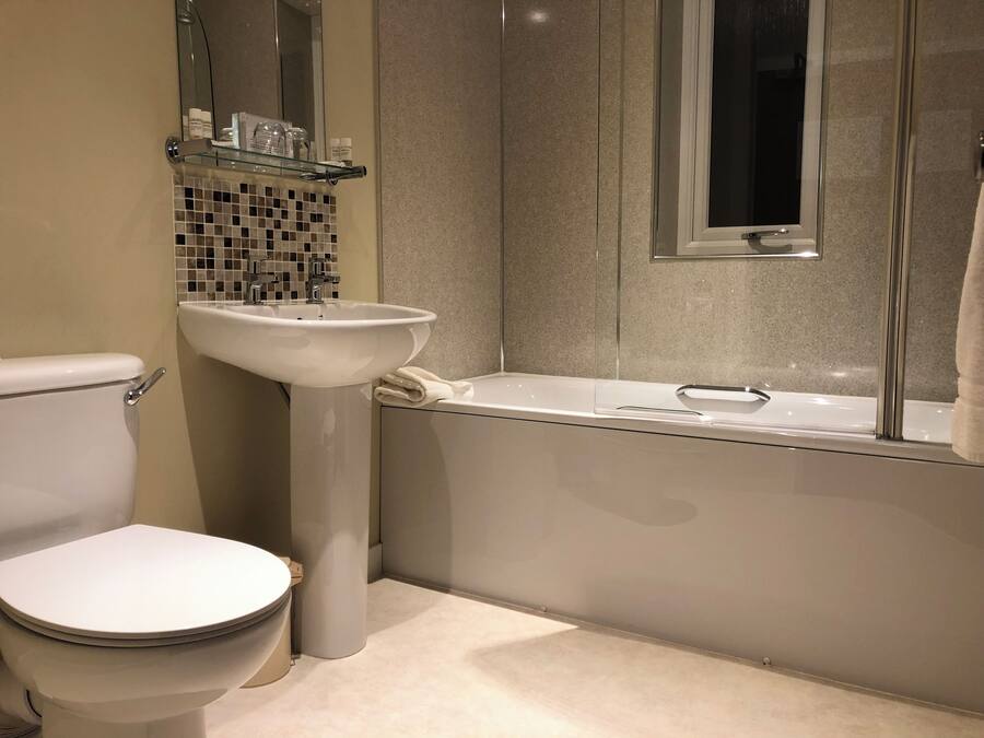 A modern bathroom with a toilet, sink, and bathtub.
