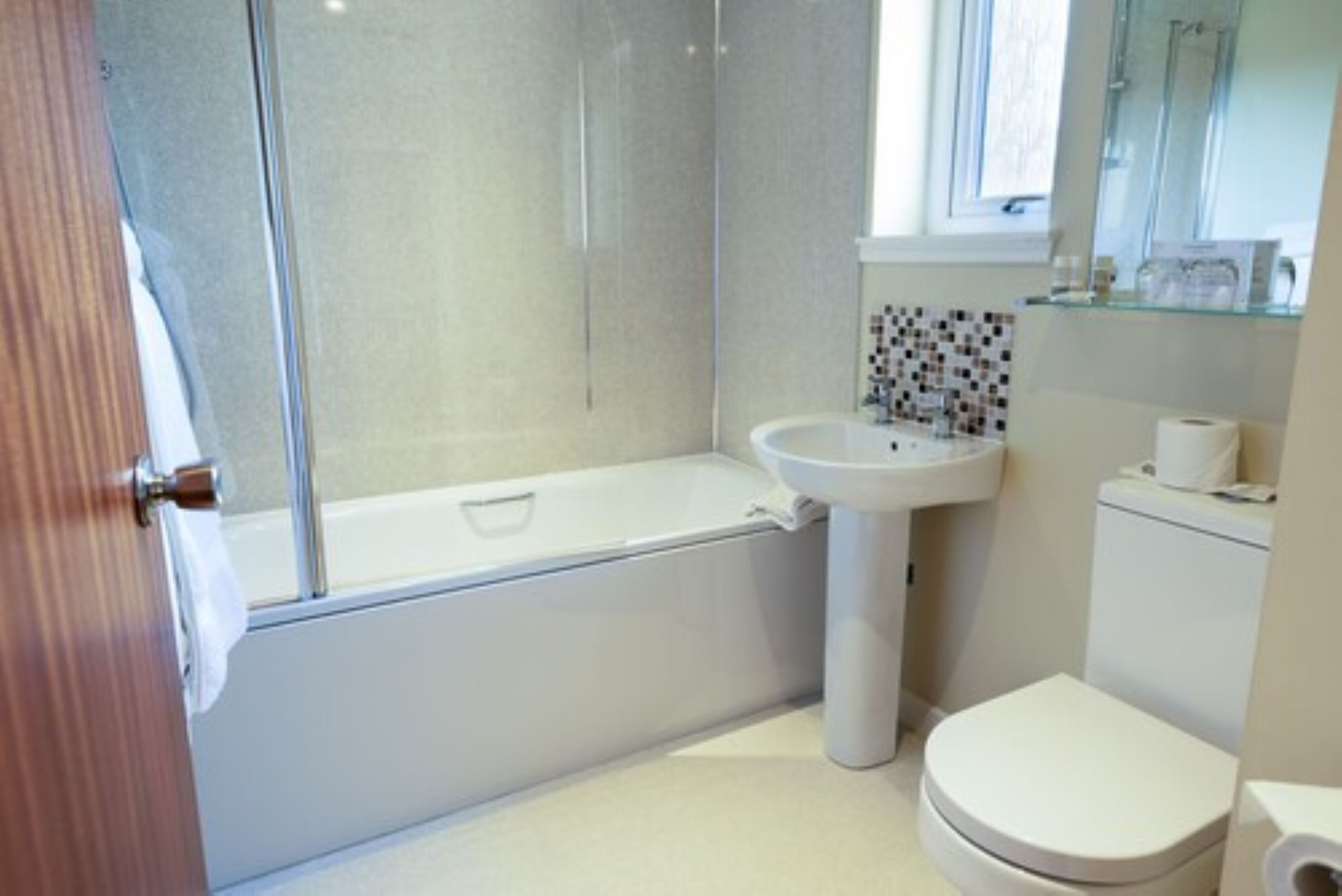 A bathroom with a bathtub, sink, and toilet.