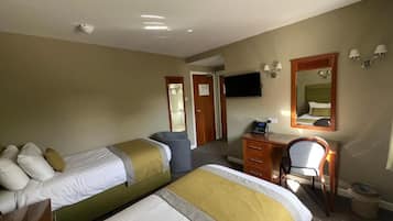 A hotel room with two beds, a desk, a chair, a television, and a mirror.