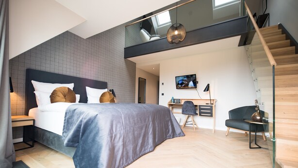 Une chambre à coucher moderne avec un lit, un bureau et une chaise.
